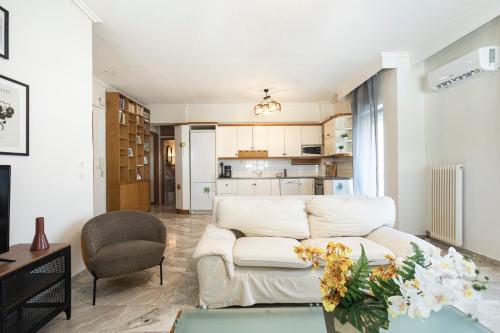 ein Wohnzimmer mit einem weißen Sofa und einem Tisch in der Unterkunft Houseloft Kalamaria Highview in Thessaloniki