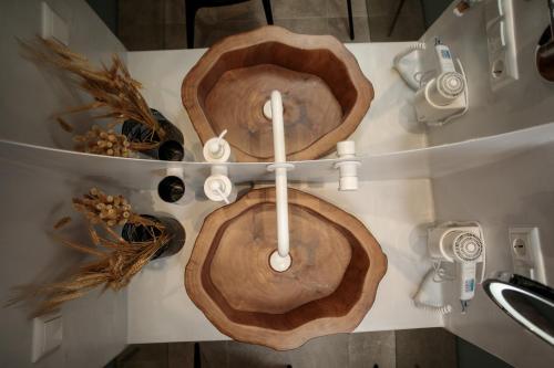 dwie drewniane miski na ladzie w łazience w obiekcie Annio studios w mieście Plaka