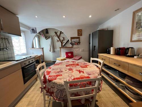 une cuisine avec une table et un réfrigérateur dans l'établissement Charmant gîte au coeur du Centre Ville, à Gérardmer