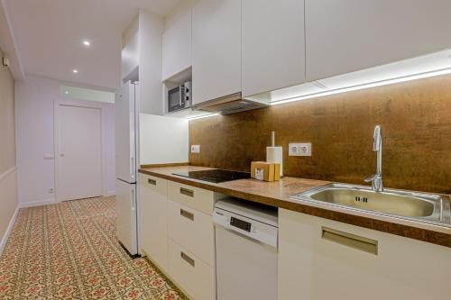 a kitchen with white cabinets and a sink at Alcam Books in Barcelona