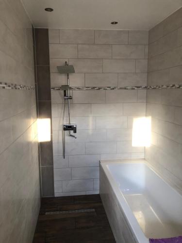 La salle de bains est pourvue d'une baignoire et d'une douche éclairée. dans l'établissement Ferienwohnung Eisenach Meyer, à Eisenach