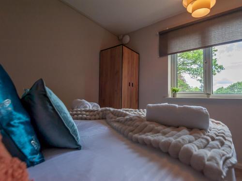 um quarto com uma cama grande com almofadas e uma janela em Pass the Keys Couples Haven Horsforth em Leeds