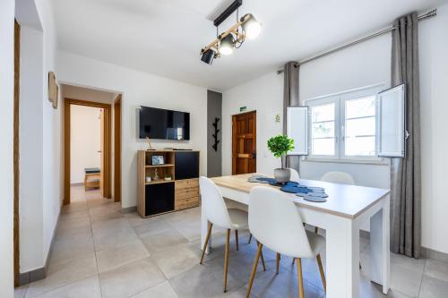 a kitchen and dining room with a white table and chairs at Casa Memória in Vila do Bispo