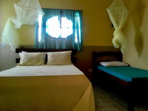 a bedroom with a bed and a window and a windowseat sqor at Falésias de Carapibus in Conde