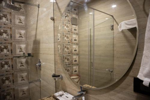 a bathroom with a shower with a round mirror at Ambala Haveli in Ambāla