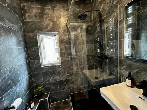 bagno con lavandino, doccia e specchio di Stylish studio near Regent’s Park n7 a Londra