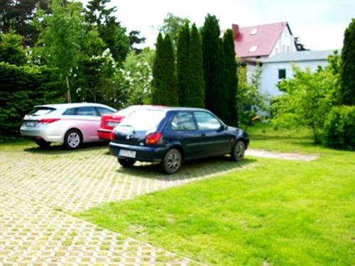 Dos coches aparcados en una entrada en un patio. en Ferienhaus DH-38879, en Lubmin