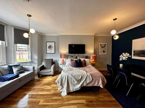 a bedroom with a bed and a living room with a couch at Stylish studio near Regent’s Park n7 in London