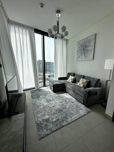 a living room with a couch and a large window at Cosy 1 bedroom Burj Khalifa view in Dubai