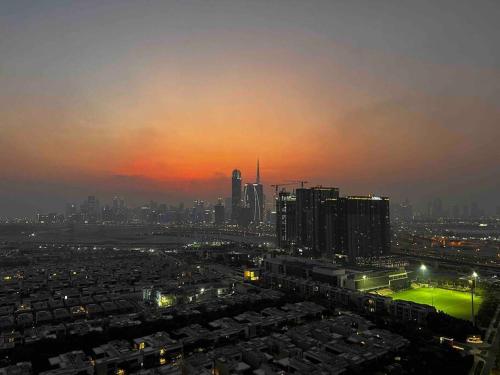 a view of a city at night with the sun setting at Cosy 1 bedroom Burj Khalifa view in Dubai