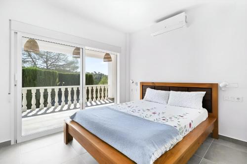 a bedroom with a bed and a large window at Villa KIP, private pool & jacuzzi surrounded by nature in Pinar de Campoverde