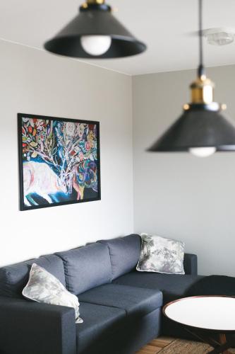 a living room with a blue couch and a painting at Hotell Klimpfjäll in Klimpfjäll