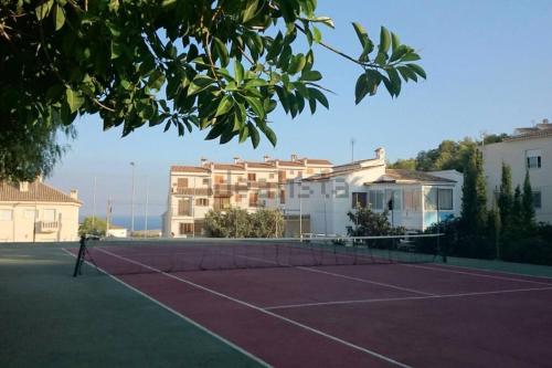 una pista de tenis con una red frente a algunos edificios en Apartamento en el casco antiguo., en Altea