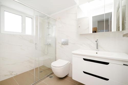 uma casa de banho branca com um WC e um lavatório em GK Plato Academy em Atenas