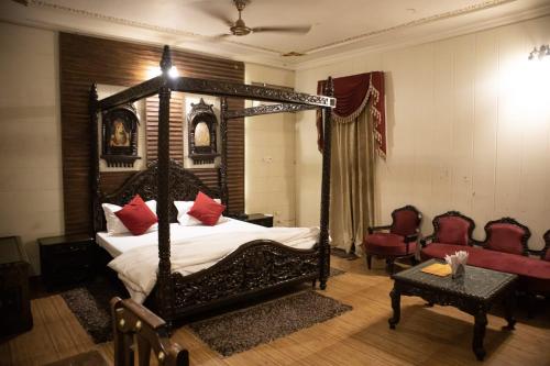 a bedroom with a canopy bed with red pillows at Ambala Haveli in Ambāla