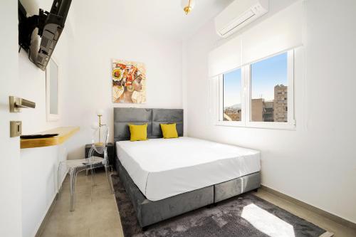 um quarto branco com uma cama e uma janela em GK Plato Academy em Atenas