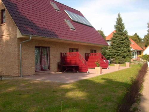 a house with two red chairs in front of it at Ferienwohnungen mit Boot DH-20952 in Lubmin