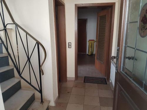 einen Flur mit Treppe und eine Tür mit Tisch in der Unterkunft Freizimmer in Aßlar Klein-Altenstädten 