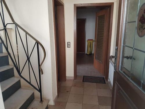 a hallway with stairs and a door with a table at Freizimmer in Aßlar Klein-Altenstädten 