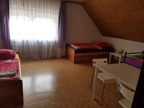 Zimmer mit 2 Betten, einem Tisch und einem Fenster in der Unterkunft Freizimmer in Aßlar Klein-Altenstädten 