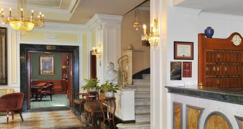 eine Lobby mit einer Treppe, einem Tisch und Stühlen in der Unterkunft Hotel Mecenate Palace in Rom