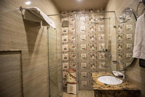 uma casa de banho com uma cabina de duche em vidro e um lavatório. em Ambala Haveli em Ambāla