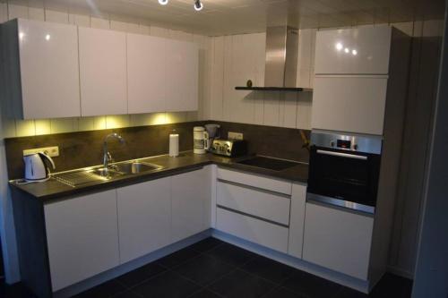 a kitchen with white cabinets and a sink at "Au Phil du Temps" by Phils Cottages in Érezée