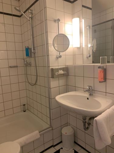 a bathroom with a shower and a sink and a tub at Hotel Sächsischer Hof in Meiningen