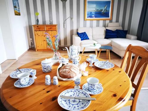 drewniany stół z niebiesko-białymi daniami w obiekcie Ferienwohnung Ole - DH w mieście Wusterhusen