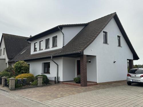 Biały dom z czarnym dachem w obiekcie Ferienwohnung Ole - DH w mieście Wusterhusen