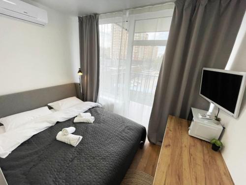 a bedroom with two towels on a bed with a television at CUBE House in Kyiv