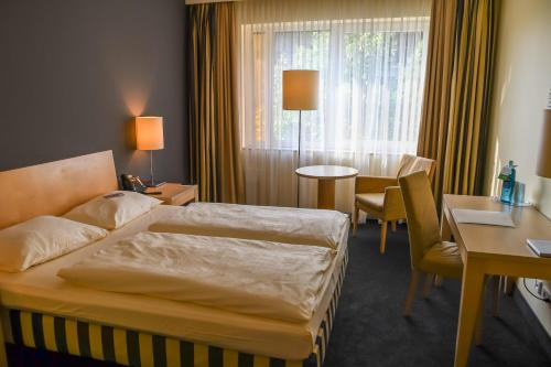 Säng eller sängar i ett rum på relexa Hotel Ratingen City