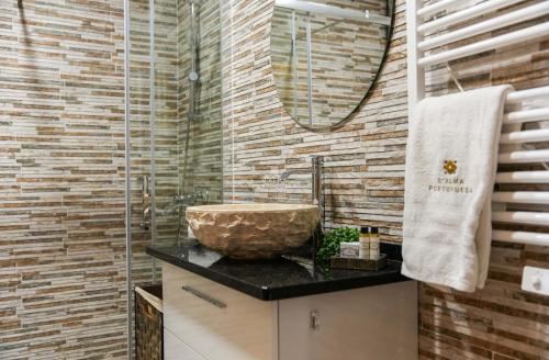 a bathroom with a stone sink and a mirror at Apartamento Tocano Beach - By Dalma Portuguesa in Albufeira