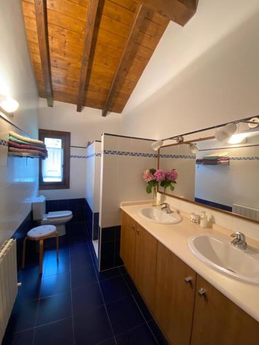 a bathroom with two sinks and a toilet in it at Alberroakoborda in Ituren