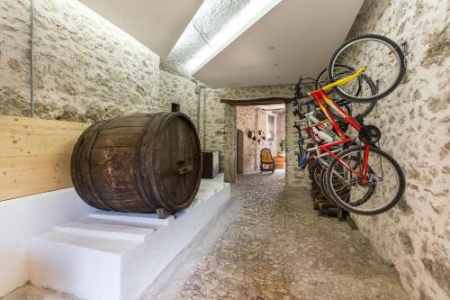 una bicicleta está colgando en la pared junto a un barril en La Loggia Sul Nera, en Arrone