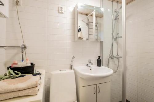 a white bathroom with a sink and a shower at Modern 31sqm studio in Helsinki in Helsinki