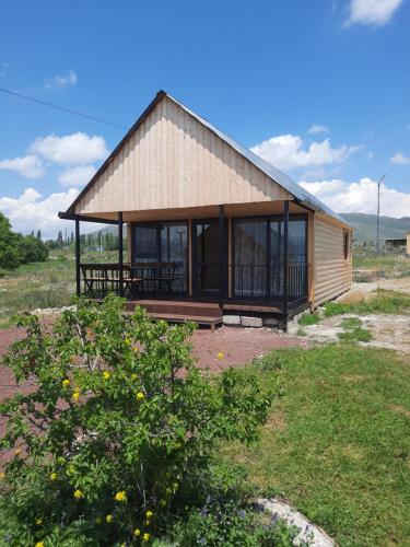 a small wooden house with a large window at Nirok in Sevan