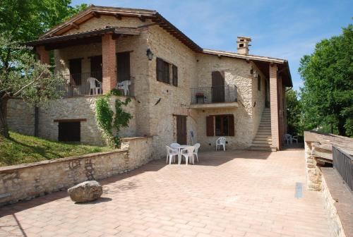 a stone house with a patio in front of it at Spoleto by the pool in Spoleto