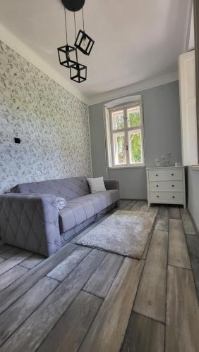 1 dormitorio con 1 cama y suelo de madera en Seoska kuća Totđerđ, 
