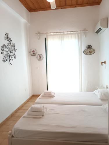 two beds in a room with a window at Skardamoula's Studios n Apartments in Kardamili