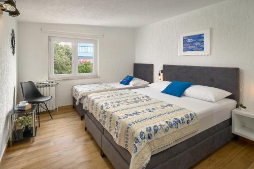 a bedroom with two beds and a window at Apartmani Biserka in Mandre