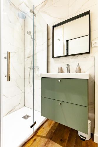 La salle de bains est pourvue d'une coiffeuse verte et d'une douche. dans l'établissement L'Hermine - Coquet - Port - Linge inclu, à Vannes