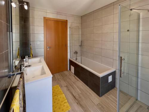 a bathroom with a tub and a sink and a shower at Villa Sonata in Ingrina Sol in Raposeira