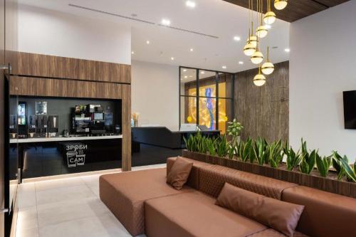 a living room with a brown couch and a bar at CUBE House in Kyiv