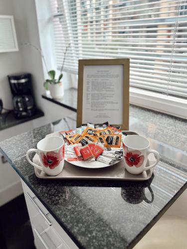 a tray with a plate of food and two cups on a counter at Canary Wharf - Luxury Apartments in London