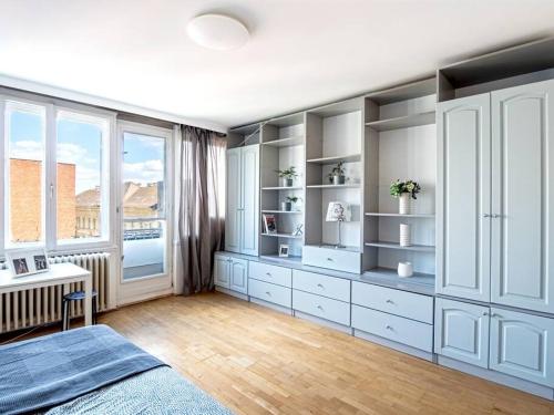 a bedroom with white cabinets and a desk and a window at Shiny Buda Studio in Budapest