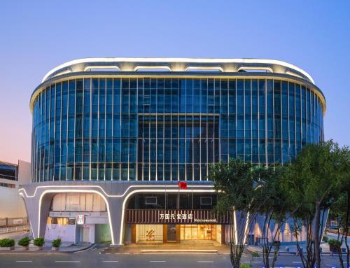 un grand bâtiment avec beaucoup de fenêtres dans l'établissement Guangzhou Wogo Yuanbao Hotel - Zhujiang New Town with free coffee, à Canton
