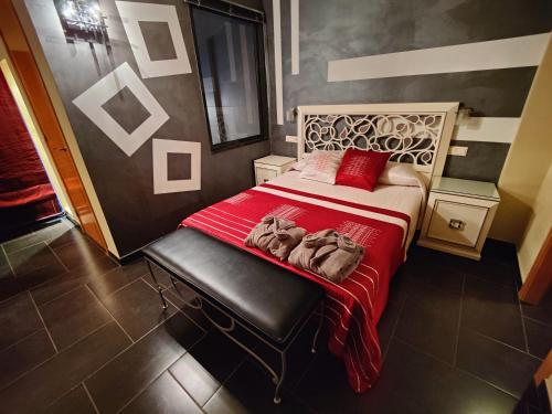 a bedroom with a large bed with a red blanket at Hostal Manel in Pineda de Mar