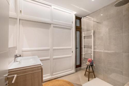 La salle de bains blanche est pourvue d'un lavabo et d'une douche. dans l'établissement Casa en Parque Nacional del Teide, à Las Cañadas del Teide