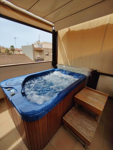 a jacuzzi tub on a balcony with a bench at Hostal Manel in Pineda de Mar